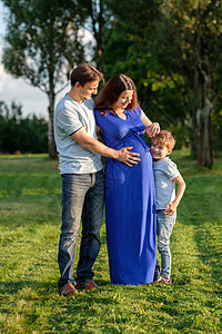幸福的怀孕家庭,三个期待新的婴儿爸爸妈妈小男孩拥抱户外图片