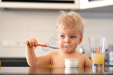 可爱的岁小男孩用勺子吃酸奶可爱的岁小男孩用勺子吃酸奶蹒跚学步的孩子肮脏凌乱的脸图片
