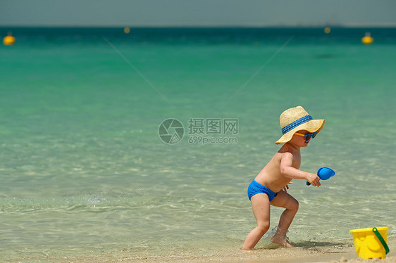 两岁的蹒跚学步的孩子海滩上玩耍两岁的蹒跚学步的男孩海滩上玩海滩玩具图片