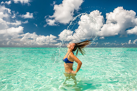 女人海洋里用头发泼水女人用头发海里溅水背景图片