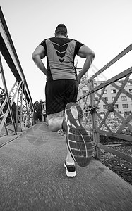 轻的运动男子慢跑过桥阳光明媚的早晨城市高清图片