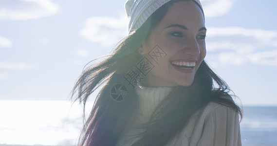 位穿着秋装海滩上微笑的轻女人的肖像背景图片