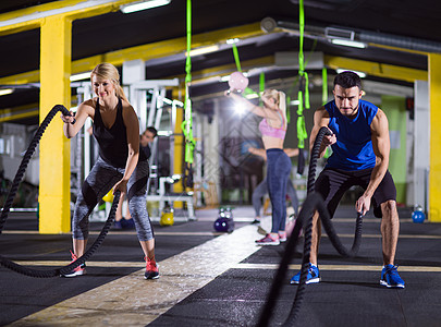 轻的健康运动夫妇功能训练健身房锻炼,用战斗绳交叉健身运动运动夫妇战斗绳交叉健身运动图片