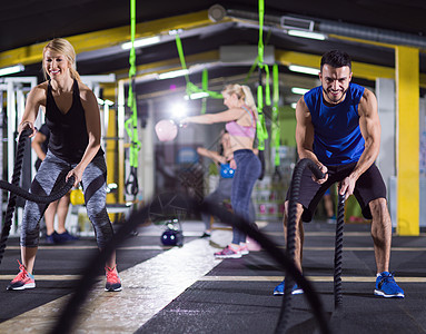轻的健康运动夫妇功能训练健身房锻炼,用战斗绳交叉健身运动运动夫妇战斗绳交叉健身运动图片