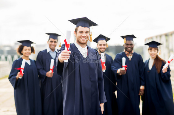 教育,毕业人的群快乐的国际学生迫击炮板学士学位礼服与文凭文凭的迫击炮板上快乐的学生图片