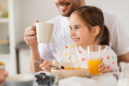 家庭,饮食人的快乐的父亲女儿家里吃早餐幸福的家庭家里喝果汁早餐图片