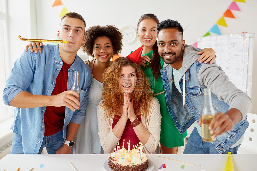 公司人的快乐的同事队与非酒精饮料蛋糕庆祝生日办公室聚会快乐的同事办公室生日聚会上吃蛋糕图片