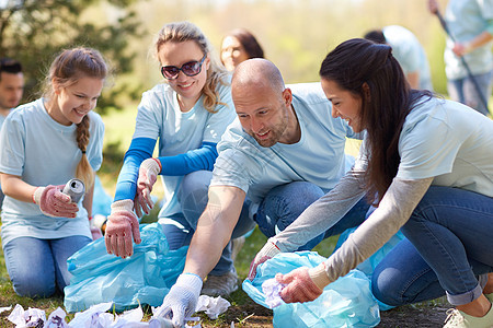 志愿服务慈善人与生态理念公园垃圾袋清洁区的群快乐志愿者志愿者用垃圾袋清洁公园区域图片