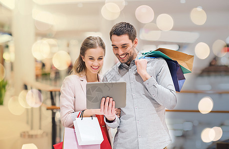 销售,消费主义,技术人的快乐的轻夫妇与购物袋平板电脑电脑手指商场夫妇与平板电脑购物袋商场图片