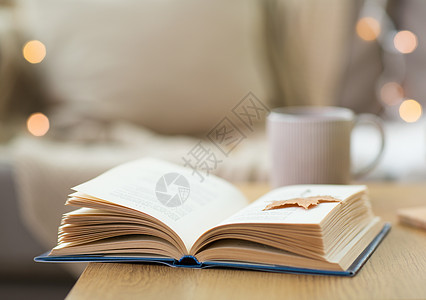 家里木桌上秋叶的书背景图片