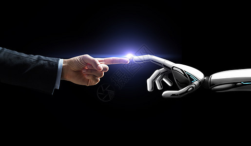人工智能,未来技术商业机器人人的手与闪光灯黑色背景机器人人类的手闪过黑色的光图片