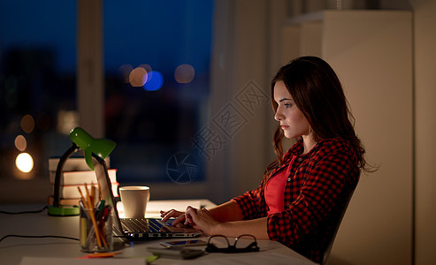 教育,自由职业,技术,过度工作人的女人学生女孩家里的笔记本电脑上打字学生妇女晚上家用笔记本电脑打字图片