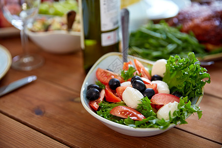 健康饮食,素食烹饪碗蔬菜沙拉与西红柿,橄榄马苏里拉奶酪木桌上木桌上马苏里拉蔬菜沙拉图片