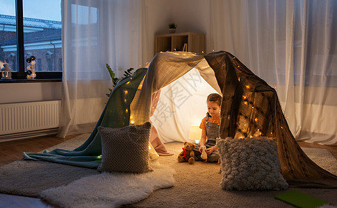 童潮湿的快乐的小女孩带着玩具孩子们的帐篷里家家里玩具的小女孩孩子们的帐篷里图片