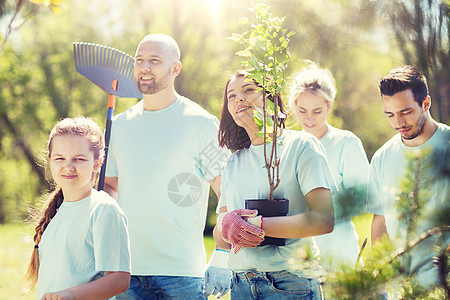 志愿服务慈善人生态理念群带着树苗耙公园散步的快乐志愿者群公园里着树耙的志愿者图片