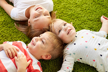 童,休闲家庭观念快乐的孩子躺地板地毯上快乐的小孩子躺地板地毯上图片