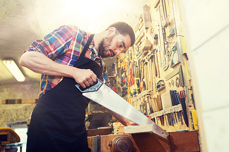 专业,木工,木工人的木匠工作与锯木板车间木匠车间里用锯子木头工作木匠车间里用锯子木头工作图片