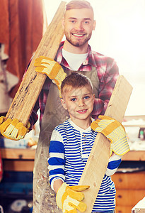 家庭,木工,木制品人的快乐的父亲小儿子车间搬运木板快乐的父子车间用木板快乐的父子车间用木板背景图片
