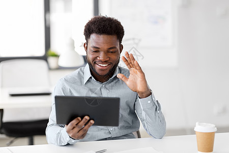 商业,技术通信快乐的微笑非裔美国商人办公室的平板电脑上进行视频聊天商人办公室的平板电脑上进行视频聊天商人办图片