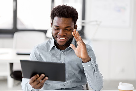 商业,技术通信快乐的微笑非裔美国商人办公室的平板电脑上进行视频聊天商人办公室的平板电脑上进行视频聊天商人办图片