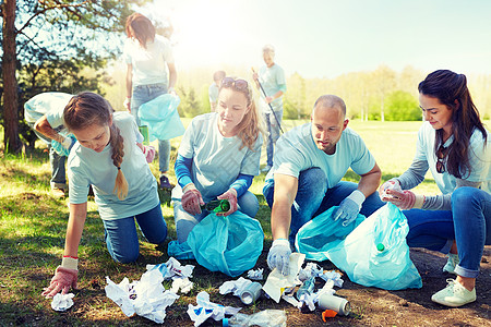 志愿服务慈善人与生态理念公园垃圾袋清洁区的群快乐志愿者志愿者用垃圾袋清洁公园区域志愿者用垃圾袋清洁公园区域图片