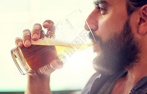 人,饮料,酒精休闲近距离的轻人喝啤酒璃酒吧酒吧靠近酒吧酒吧喝啤酒的人靠近酒吧酒吧喝啤酒的人图片