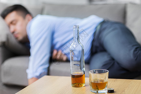 酒精成瘾人们的瓶子与杯威士忌桌子上熟睡的醉汉瓶酒桌子上熟睡的醉汉瓶酒桌子上熟睡的醉汉图片