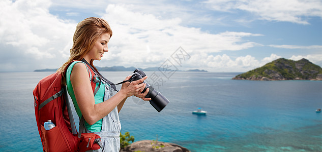 海滩上女人带着背包相机旅行摄影高清图片