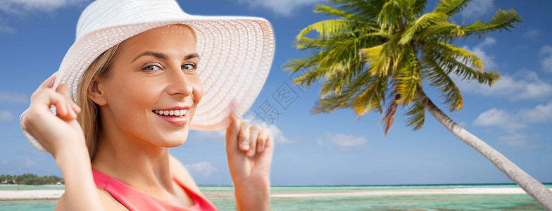 旅行,暑假旅游美丽的微笑女人的肖像异国情调的热带海滩与棕榈树背景海滩上戴着太阳帽微笑的女人的肖像海滩上戴着太阳图片