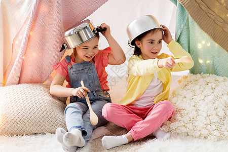 童潮湿的快乐的小女孩家里的孩子帐篷里玩炊具带厨房用具的女孩家里的帐篷里玩带厨房用具的女孩家里的帐篷里玩图片