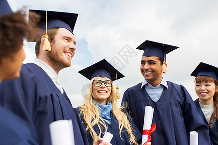 教育毕业人的群快乐的国际学生穿着迫击炮板学士学位礼服与文凭文凭的迫击炮板上快乐的学生文凭的迫击炮板上快图片