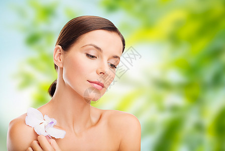 健康美丽的美丽的女人与兰花绿色的自然背景绿色背景上兰花花的女人绿色背景上兰花花的女人图片