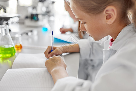 教育科学儿童学校实验室学化学的女孩的特写写作练册学校实验室学化学的女孩图片