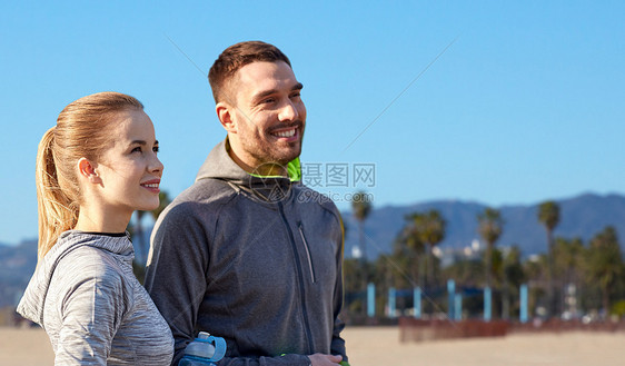 健身,运动人的微笑夫妇与瓶子的水威尼斯海滩背景加利福尼亚几个运动员威尼斯海滩上喝水图片