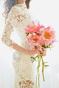 生活方式时尚照片,美丽的轻女子穿着白色花边连衣裙与粉红色牡丹假期活动婚礼情人节春天开花了夏天的季节图片