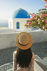 穿着白色连衣裙草帽的快乐女人桑托里尼岛享受假期OIA看爱琴海欧洲夏季旅游目的地希腊岛屿图片