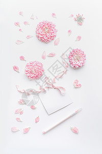 粉彩模拟粉红色的花朵花瓣,空白纸卡与丝带点笔白色桌背景,顶部视图母亲节婚礼快乐活动的贺卡布局图片