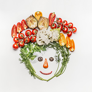趣的脸由各种新鲜蔬菜制成的白色背景,顶部视图健康清洁饮食,节食膳食素食图片