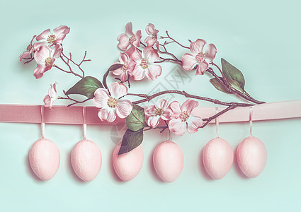 复活节贺卡与挂彩粉蛋,丝带美丽的春花装饰图片
