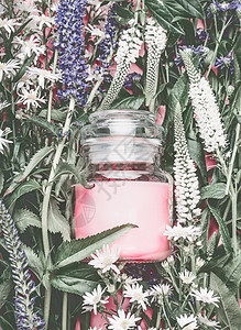 天然化妆品罐子,草药叶子野花上涂上粉红色的奶油,空白标签,用于品牌模型,顶部视图,平布局图片