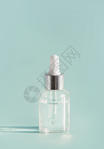 带滴管的璃瓶中的化妆品透明液体血清护肤品轻薄荷背景,正视图与美容产品的空白标签用于品牌模拟图片