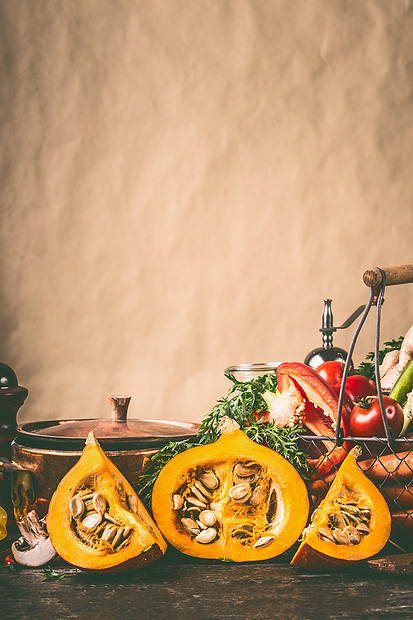南瓜半厨房的桌子上,烹饪锅配料乡村墙的背景下,正视图健康素食饮食观念秋季季节饮食图片