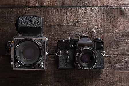 老式黑色胶卷相机棕色背景的天然木材与镜头背景图片