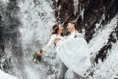 新娘新郎山瀑布的背景上图片