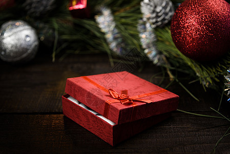 诞礼物,红色盒子,木制背景上红色丝带,周围个诞花环图片