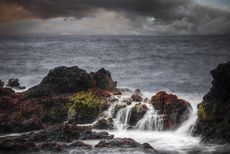 海洋中的风暴水中的石头长时间暴露时被击中的海洋中的风暴雨高清图片素材