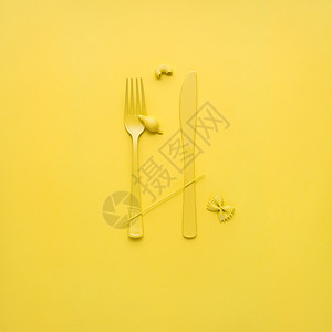 创意静物照片的叉子勺子与生意黄色背景背景图片