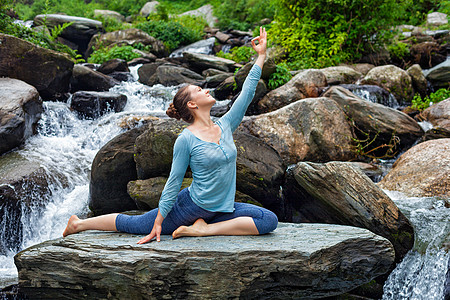 户外瑜伽轻的运动健康的女人伸展瑜伽阿莎娜EkaPadaRajakapotasana条腿的鸽子姿势热带瀑布健康的女图片