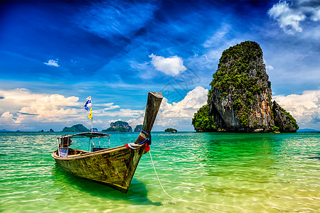 热带海滩普拉南海滩岩石上的长尾船,泰国克拉比泰国海滩上的长尾船图片