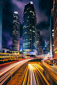 香港夜间的街道交通写字楼摩天大楼高速公路上繁忙的交通,车辆模糊,小径轻盈中国香港香港夜间的街道交通背景图片